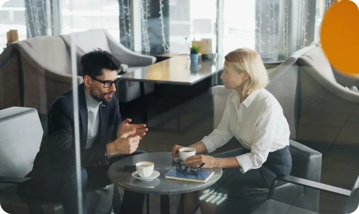 A Man And A Woman Sitting At A Table Xtktmcua Dw
