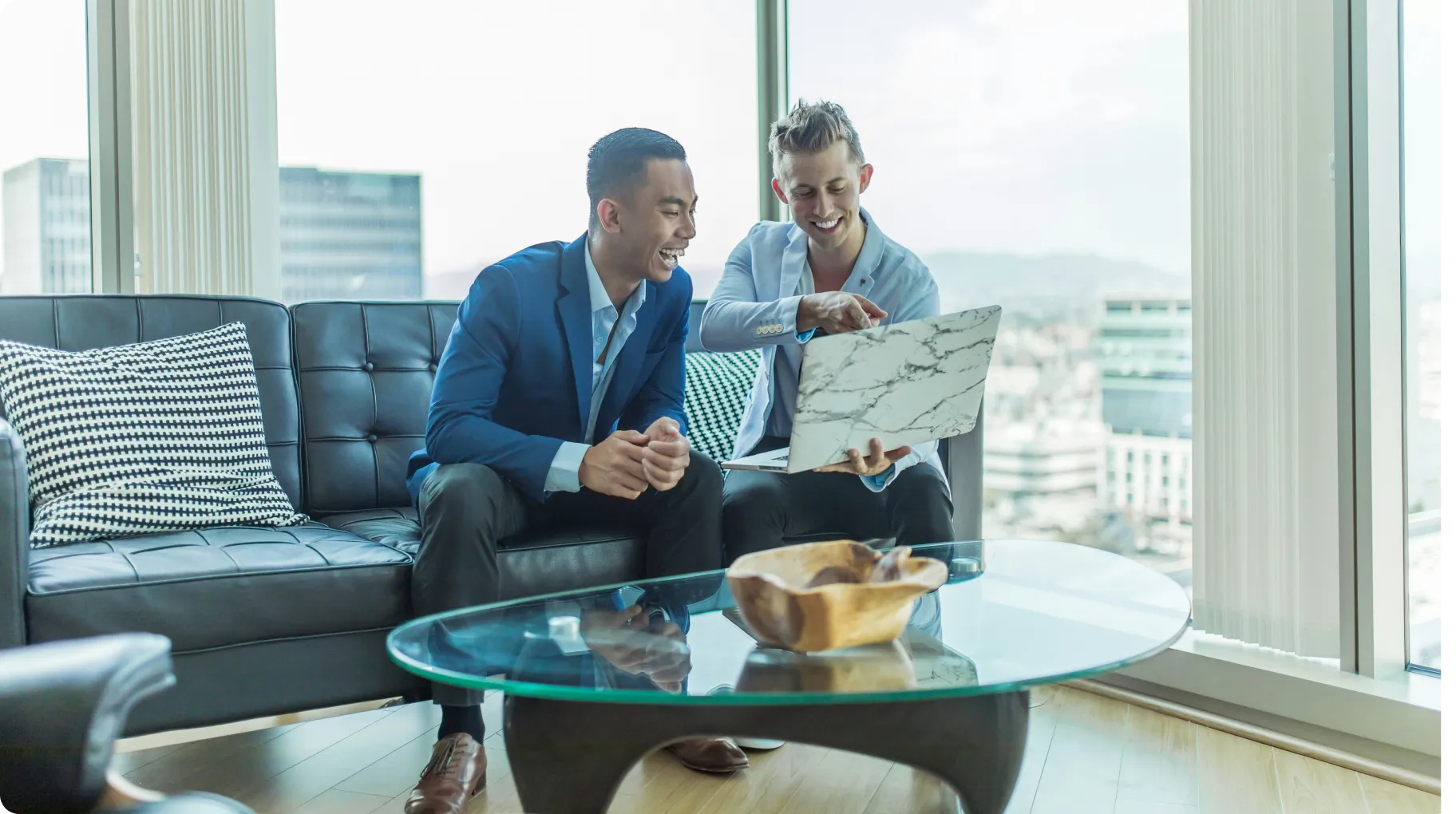 Two Men Sitting On A Couch Beside A Table