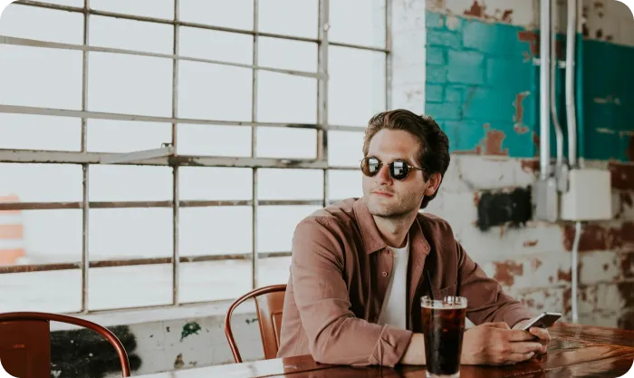 Guy Sitting At The Table With Phone ARTICLE