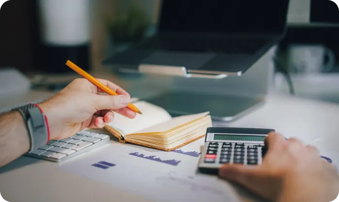 Man Using Calculator And Taking Notes