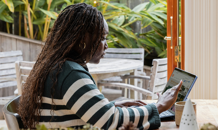 Solo entrepreneur managing business compliance from home using low-cost tools, reviewing legal structure options, registering a business name, organizing tax info, and tracking deadlines with a digital calendar