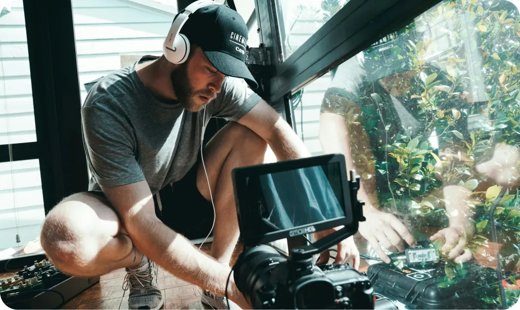 Filmmaker Recording Audio With Headphones And Camera