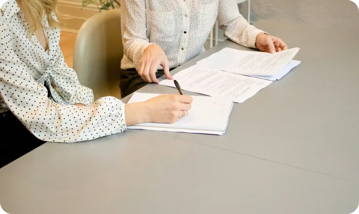 Woman Signing On White Printer Paper Beside Woman About To Touch The Documents Hjckknwcxxq